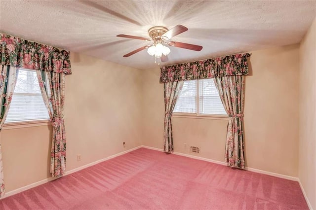 carpeted empty room with ceiling fan and a textured ceiling