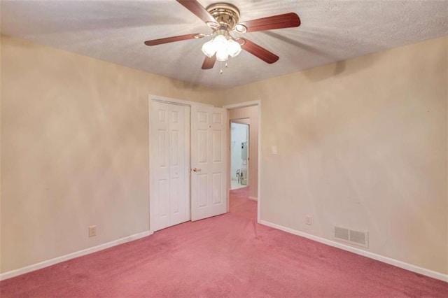 carpeted spare room with a textured ceiling and ceiling fan