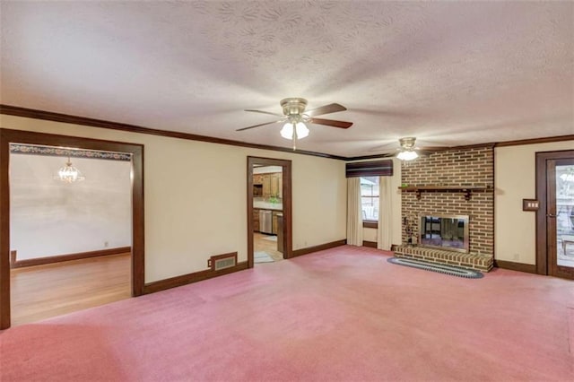 unfurnished living room with a fireplace, ornamental molding, ceiling fan, light carpet, and a textured ceiling