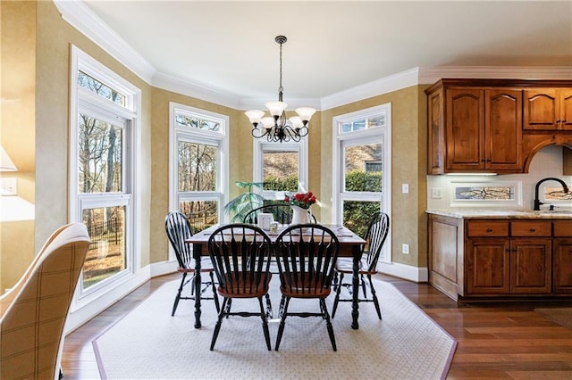 dining room featuring ornamental molding, dark hardwood / wood-style floors, sink, and a notable chandelier