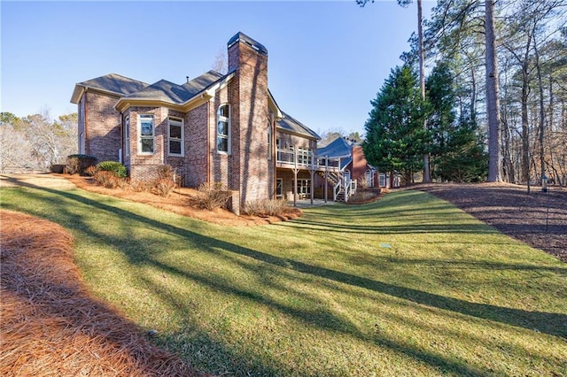 view of side of property with a wooden deck and a yard