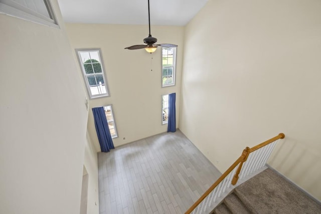 entrance foyer featuring a wealth of natural light, light hardwood / wood-style flooring, ceiling fan, and a high ceiling