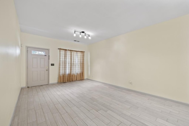 entrance foyer with rail lighting and light hardwood / wood-style floors