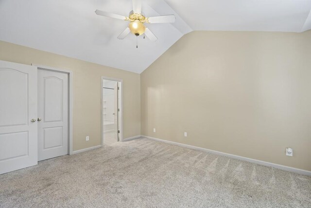 unfurnished bedroom with light carpet, ensuite bath, ceiling fan, and lofted ceiling