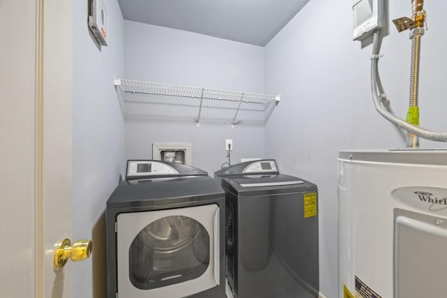 washroom with washing machine and dryer and water heater