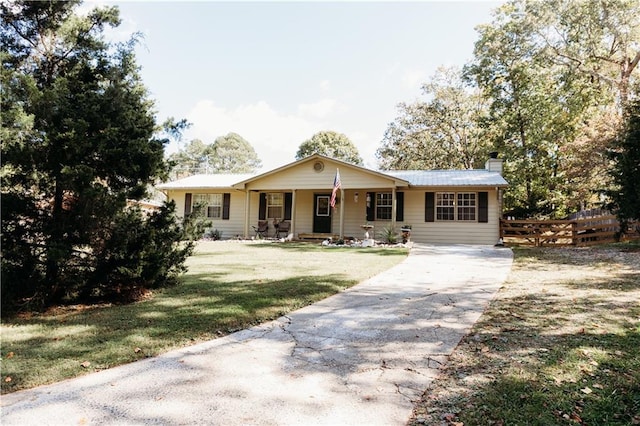 ranch-style house featuring covered porch and a front yard