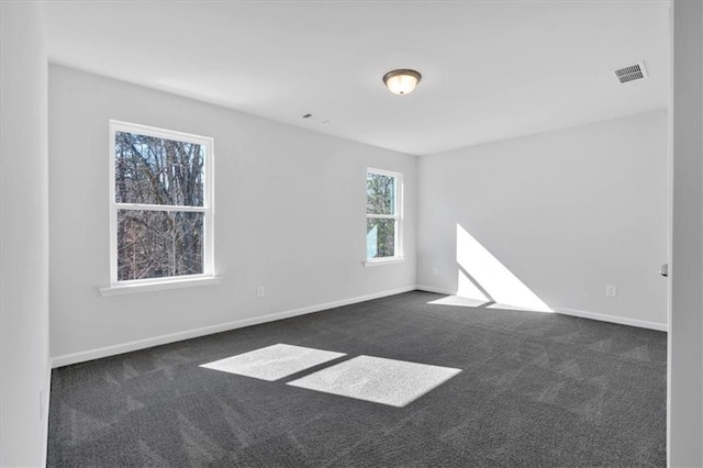 unfurnished room with dark carpet