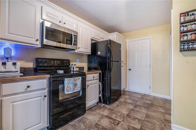 287 Jeremy Dr, Colbert, GA 30628 - kitchen featuring black appliances, dark countertops, baseboards, and white cabinets