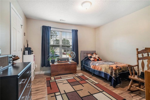 287 Jeremy Dr, Colbert, GA 30628 - bedroom featuring light wood-style floors, a textured ceiling, and baseboards