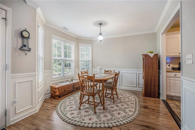 287 Jeremy Dr, Colbert, GA 30628 - dining room with wood finished floors, a textured ceiling, a decorative wall, and a wainscoted wall
