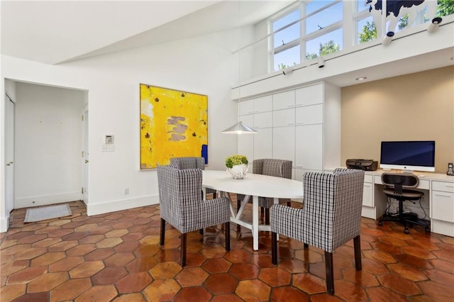 dining space featuring high vaulted ceiling