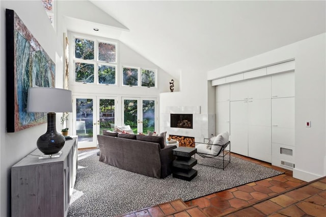 living room featuring a fireplace, french doors, and a towering ceiling