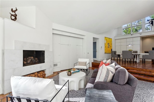 living room with a high end fireplace and high vaulted ceiling