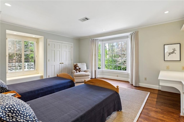 bedroom featuring crown molding, dark wood-type flooring, and multiple windows