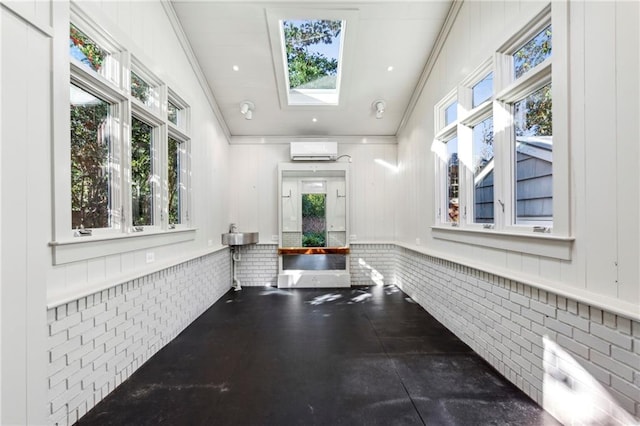 hall with a wall unit AC, a skylight, a healthy amount of sunlight, and brick wall