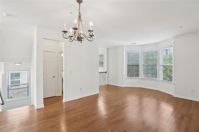 interior space featuring baseboards, wood finished floors, and a chandelier