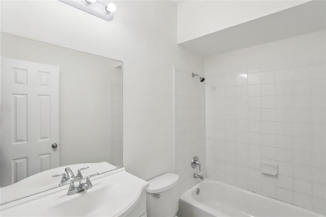 bathroom with a sink, bathing tub / shower combination, and toilet