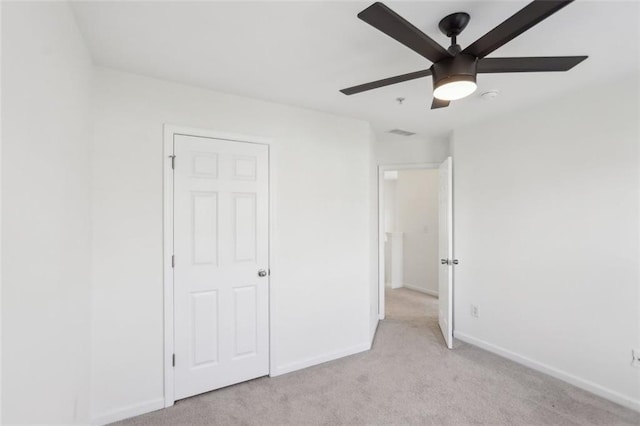 unfurnished bedroom featuring baseboards, light carpet, a ceiling fan, and visible vents
