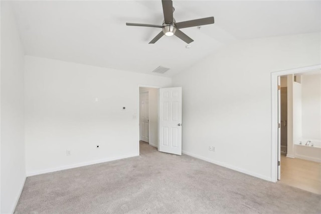 unfurnished bedroom with visible vents, carpet, baseboards, and vaulted ceiling