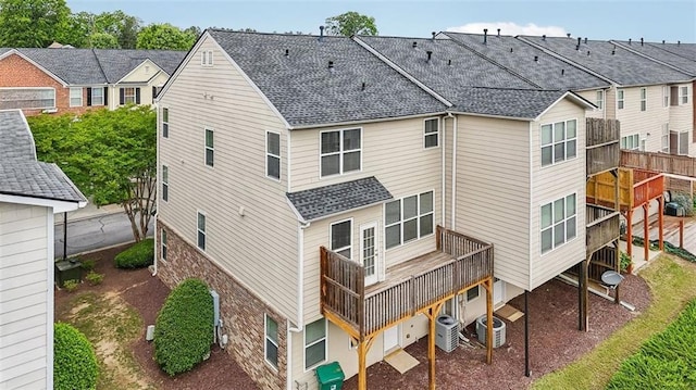 back of house featuring central AC unit and a shingled roof
