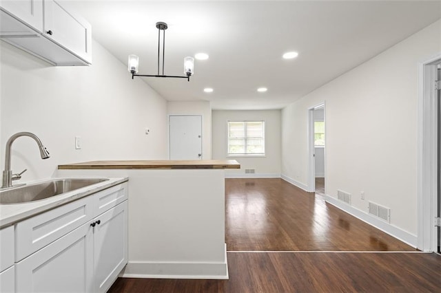 1437 Vesta Ave, East Point, GA 30344 - kitchen featuring a sink, dark wood-type flooring, white cabinetry, light countertops, and pendant lighting