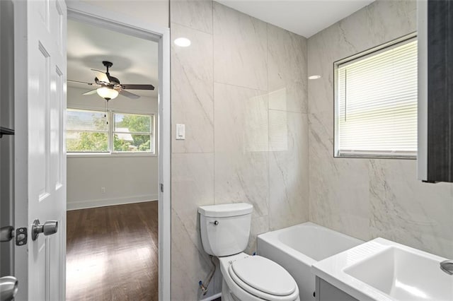 1437 Vesta Ave, East Point, GA 30344 - full bath featuring a ceiling fan, toilet, a sink, a tub to relax in, and tile walls