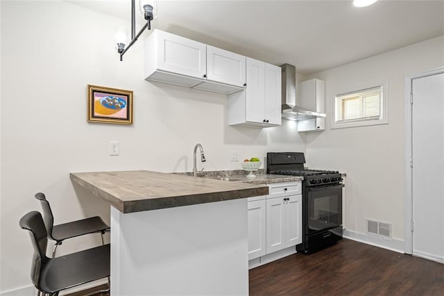 1437 Vesta Ave, East Point, GA 30344 - kitchen with black gas range, wall chimney exhaust hood, dark wood-style flooring, a sink, and a breakfast bar area