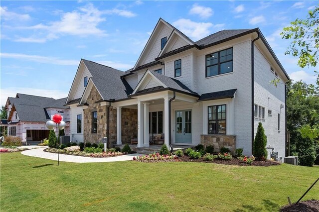 view of front of house with cooling unit, covered porch, and a front yard