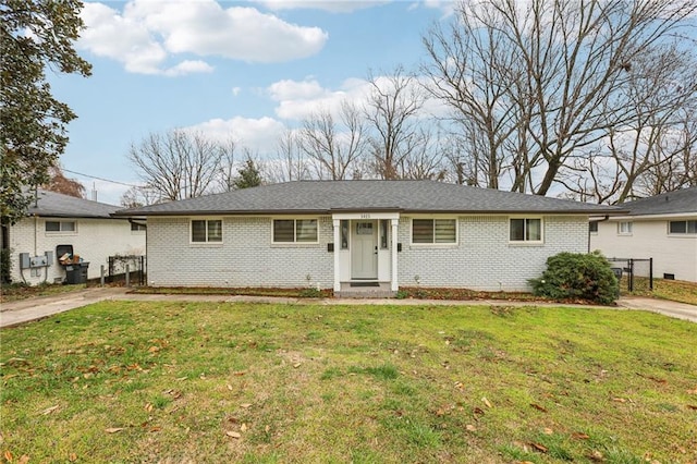 ranch-style house with a front lawn, fence, and brick siding