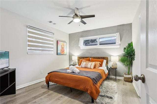 bedroom with baseboards, visible vents, ceiling fan, and wood finished floors