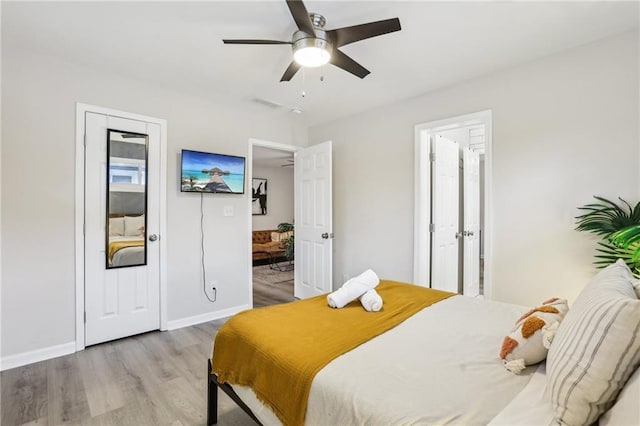 bedroom with visible vents, light wood-style flooring, connected bathroom, ceiling fan, and baseboards