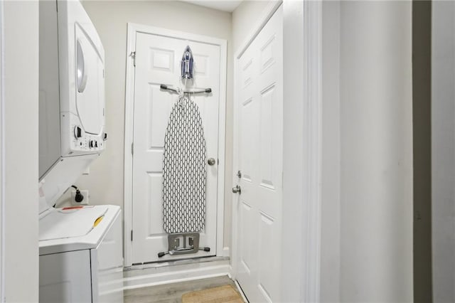 washroom featuring stacked washer and dryer and laundry area