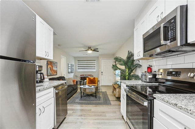 kitchen featuring stainless steel appliances, backsplash, and white cabinetry