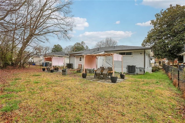 rear view of house featuring central AC unit, a lawn, a fenced backyard, a patio area, and brick siding