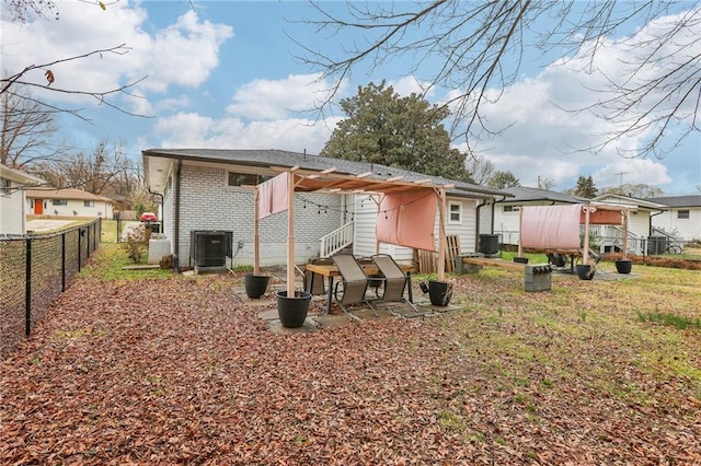 back of property with brick siding, cooling unit, fence, and a residential view