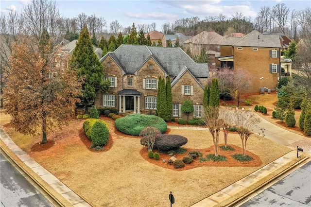 view of front of home featuring driveway, stone siding, a residential view, and central AC