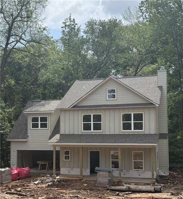 742 Joy St, Jackson, GA 30233 - view of front facade with board and batten siding, covered porch, a chimney, and roof with shingles