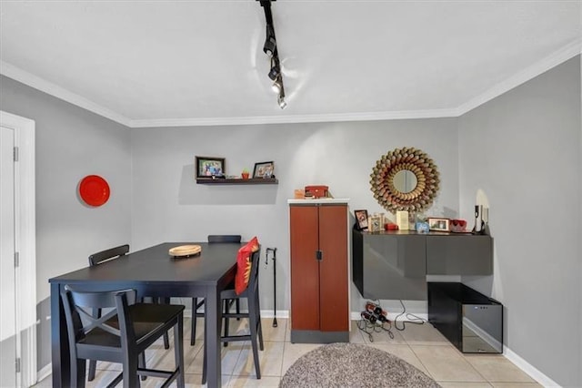 dining space featuring track lighting, ornamental molding, and light tile patterned flooring