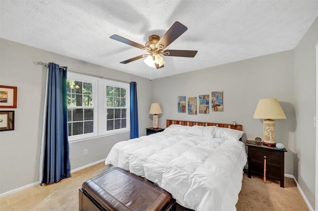 bedroom with light carpet, ceiling fan, and a textured ceiling