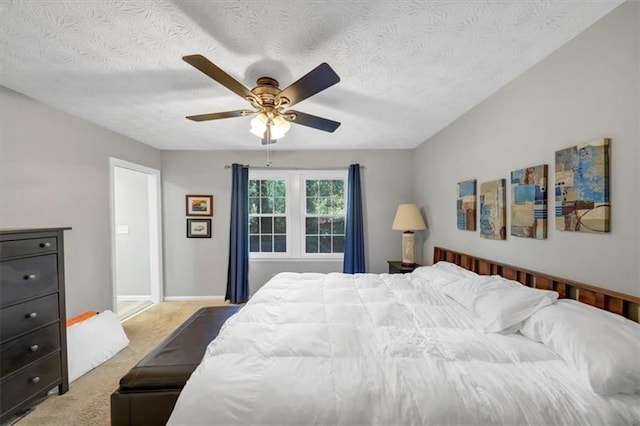 bedroom featuring ceiling fan, light carpet, and a textured ceiling