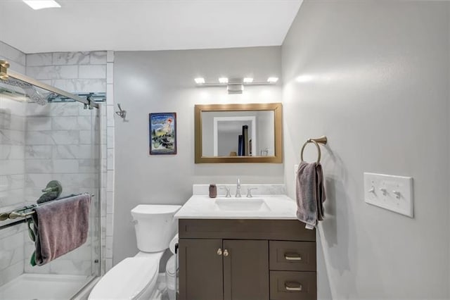 bathroom featuring vanity, toilet, and a shower with shower door