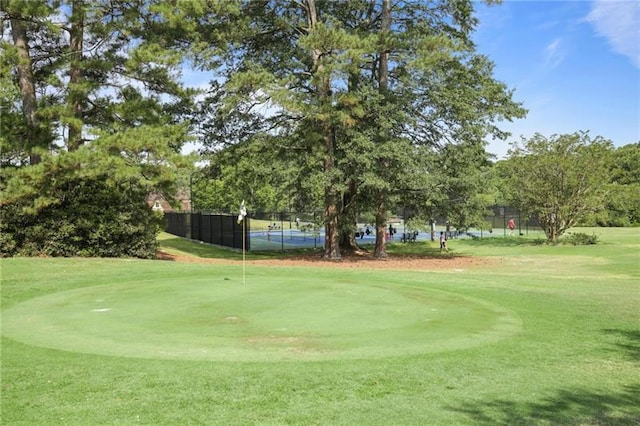 view of home's community with a lawn and tennis court