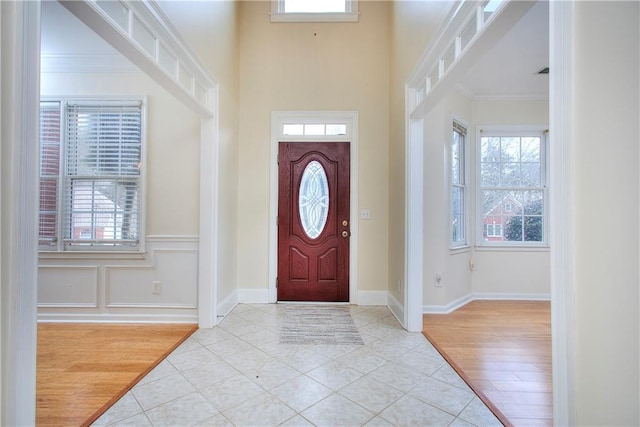 tiled foyer entrance with a healthy amount of sunlight and ornamental molding