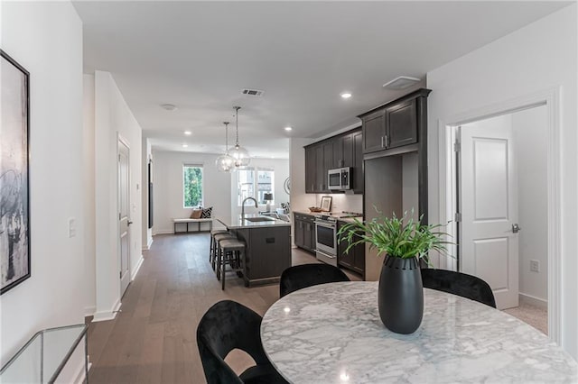 dining space with hardwood / wood-style flooring and sink