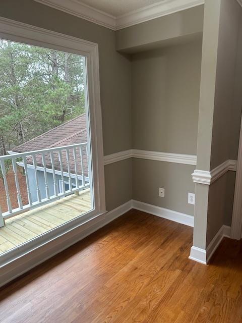 unfurnished room with hardwood / wood-style flooring and crown molding