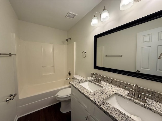 full bath with toilet, wood finished floors, double vanity, and tub / shower combination