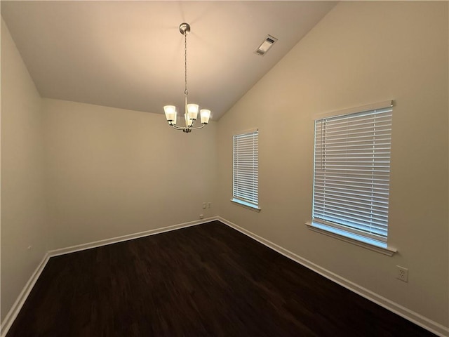empty room featuring baseboards, dark wood finished floors, a chandelier, and lofted ceiling