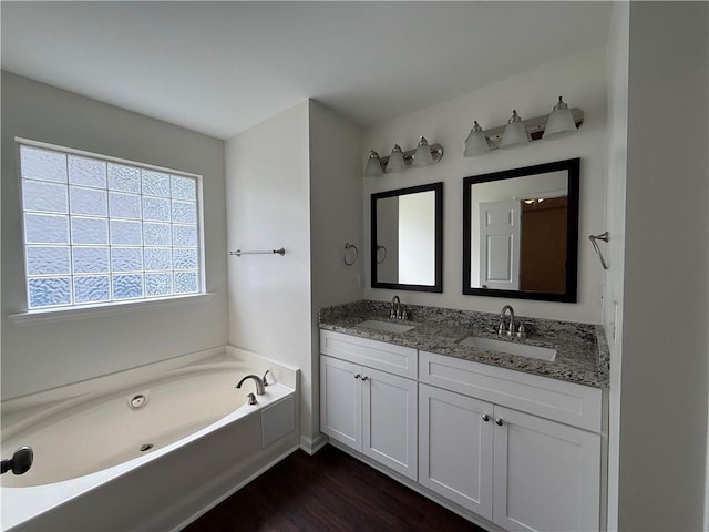bathroom featuring a garden tub, wood finished floors, and double vanity