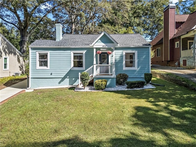 view of front of house with cooling unit and a front lawn