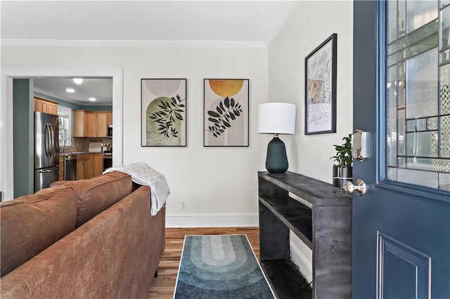 living room with dark hardwood / wood-style floors, ornamental molding, and sink